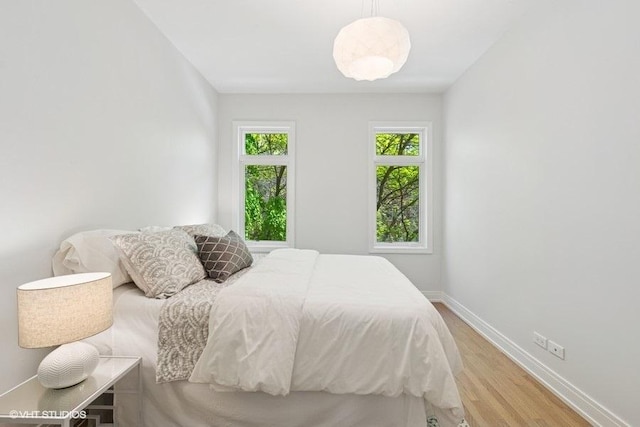 bedroom featuring light wood-type flooring and baseboards