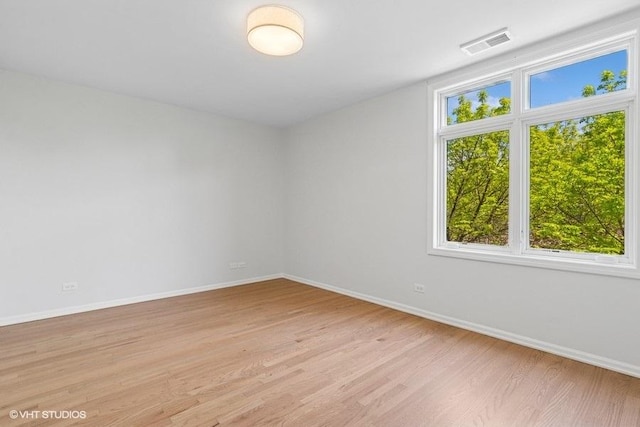 empty room featuring baseboards and light wood-type flooring