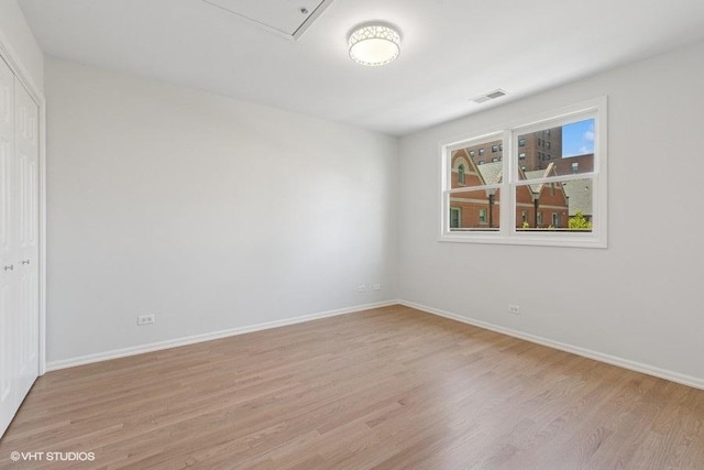 empty room featuring light wood-style flooring and baseboards