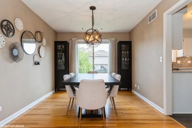 1449 Mesa Dr, Bolingbrook, IL 60490 - dining area with light wood finished floors, a chandelier, and baseboards