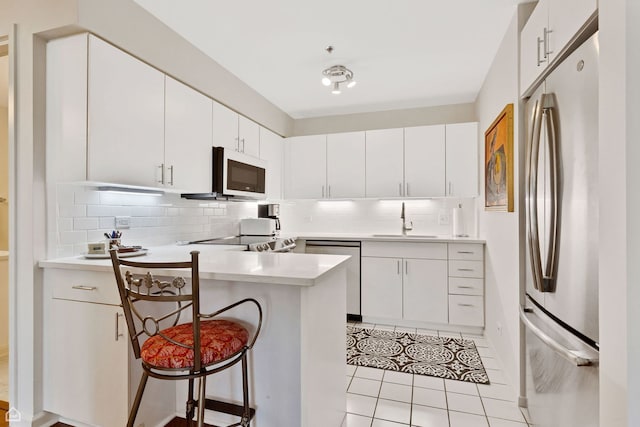6040 Arbor Ln Unit 102, Northfield, IL 60093 - kitchen with appliances with stainless steel finishes, decorative backsplash, a peninsula, and light countertops