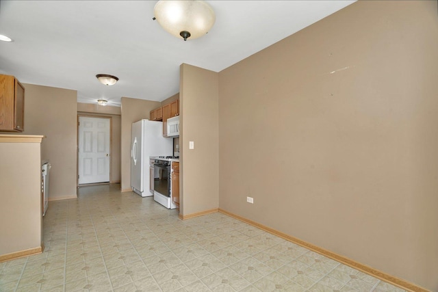 kitchen featuring white appliances, baseboards, brown cabinets, and light floors