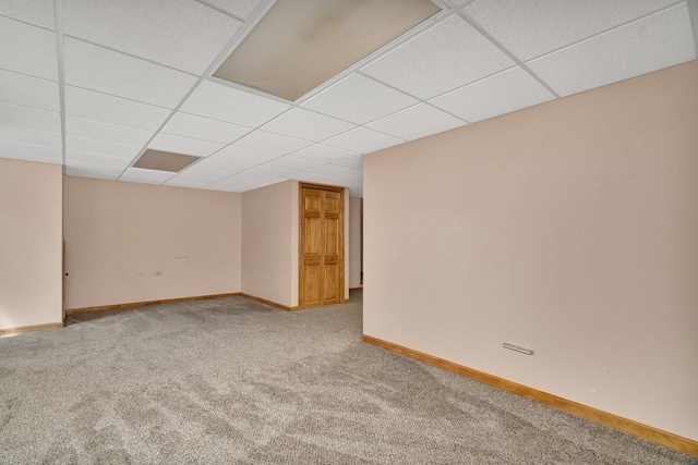 finished basement featuring carpet, baseboards, and a paneled ceiling