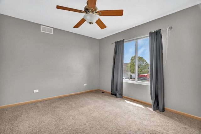 carpeted empty room featuring baseboards and ceiling fan