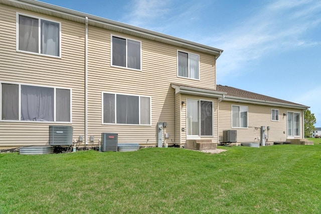 back of property featuring a yard and central AC unit