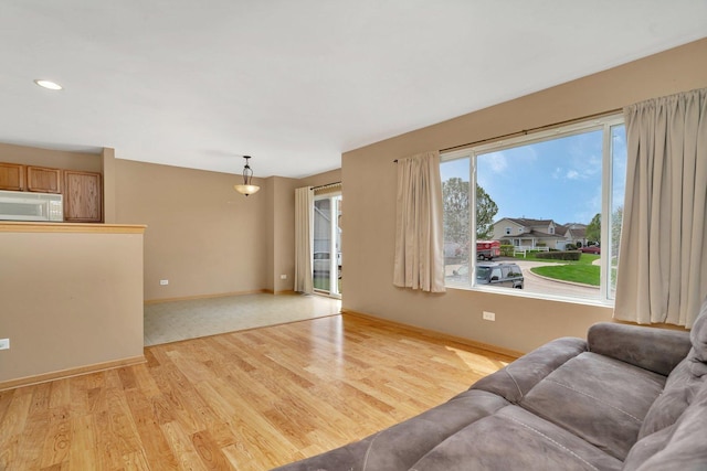 unfurnished living room featuring light wood-type flooring, baseboards, and recessed lighting