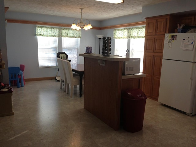 2210 E Michigan Ave, Urbana, IL 61802 - dining area featuring a chandelier, healthy amount of natural light, baseboards, and a textured ceiling