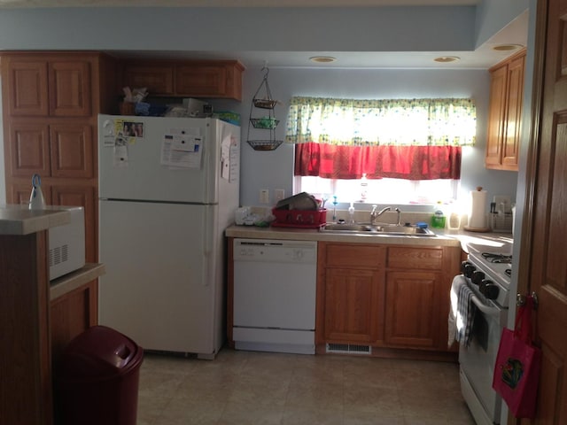 2210 E Michigan Ave, Urbana, IL 61802 - kitchen featuring white appliances, a sink, light countertops, and brown cabinetry