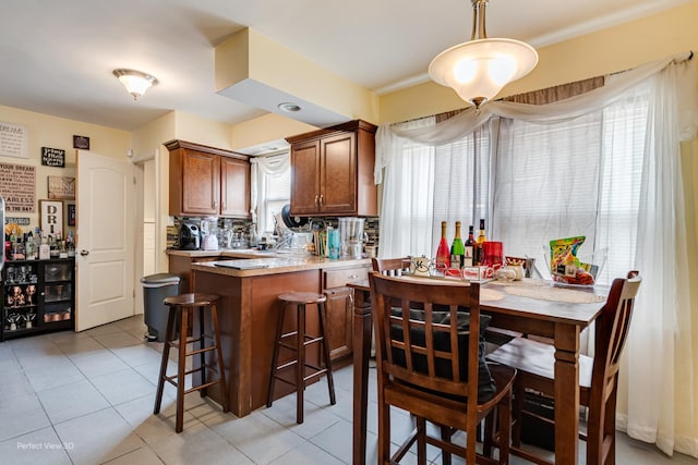 8724 S Jeffery Blvd, Chicago, IL 60617 - kitchen with brown cabinets, a peninsula, light countertops, and light tile patterned floors