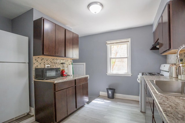 12435 S Perry Ave, Chicago, IL 60628 - kitchen featuring white appliances, under cabinet range hood, light countertops, dark brown cabinetry, and decorative backsplash