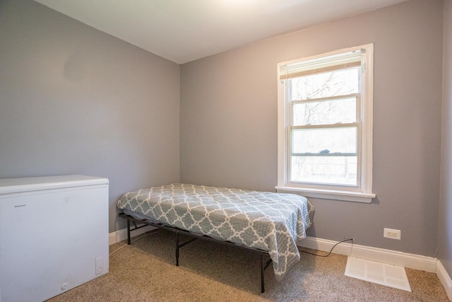 12435 S Perry Ave, Chicago, IL 60628 - carpeted bedroom with white refrigerator, multiple windows, and baseboards