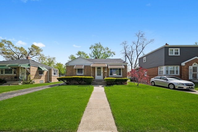 view of front facade featuring a front yard and brick siding
