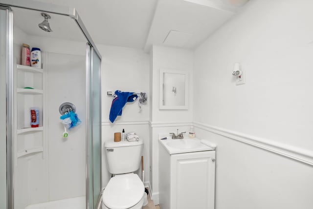 bathroom with a shower stall, toilet, and vanity