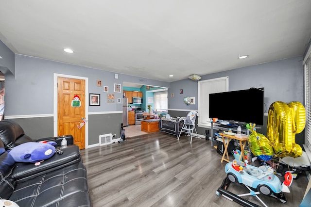 living room featuring wood finished floors, recessed lighting, and baseboards