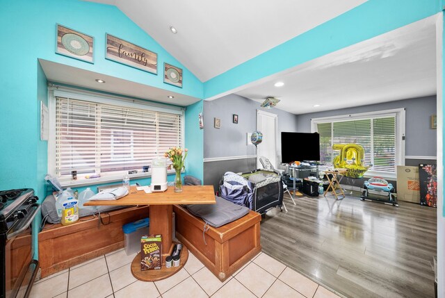 dining space with vaulted ceiling and tile patterned flooring