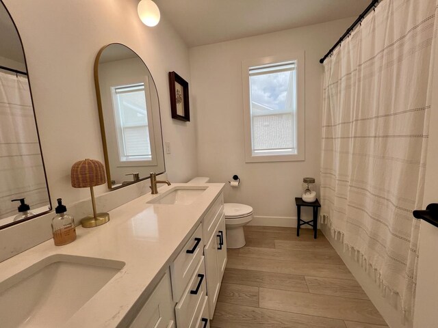 3133 Palmer Dr, Champaign, IL 61822 - full bathroom featuring wood finished floors, toilet, baseboards, and double vanity