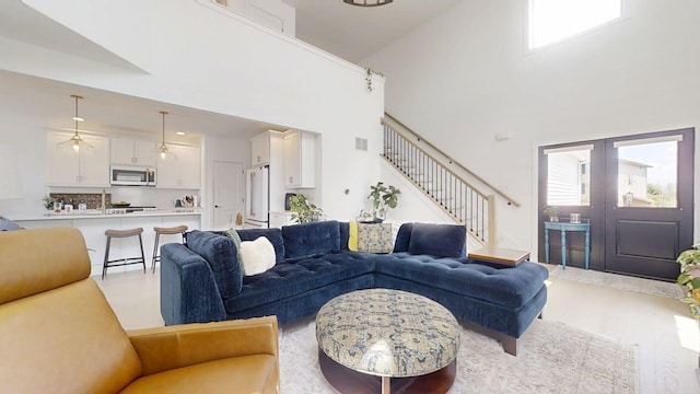3133 Palmer Dr, Champaign, IL 61822 - living area featuring stairway, a high ceiling, healthy amount of natural light, light wood-style flooring, and french doors
