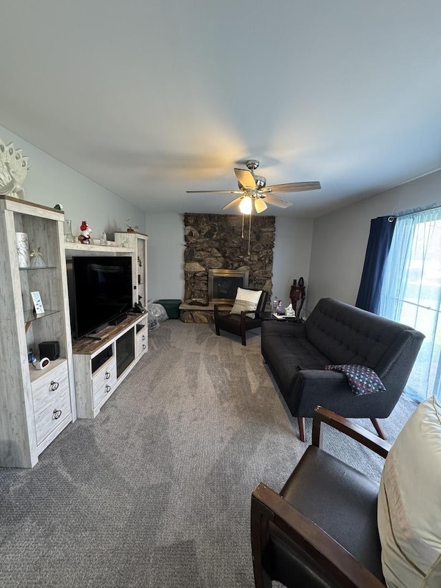 living area with ceiling fan, carpet flooring, and a fireplace