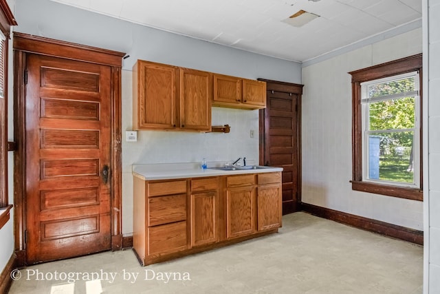491 S Dearborn Ave, Kankakee, IL 60901 - kitchen featuring a sink, light countertops, light floors, baseboards, and brown cabinets