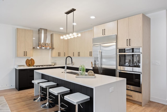 8115 E Prairie Rd, Skokie, IL 60076 - kitchen featuring stainless steel appliances, wall chimney range hood, light brown cabinets, light countertops, and recessed lighting