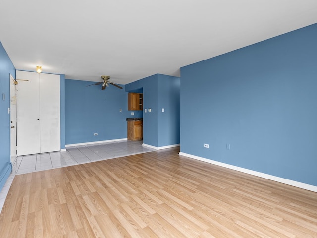 unfurnished living room with wood finished floors, ceiling fan, and baseboards