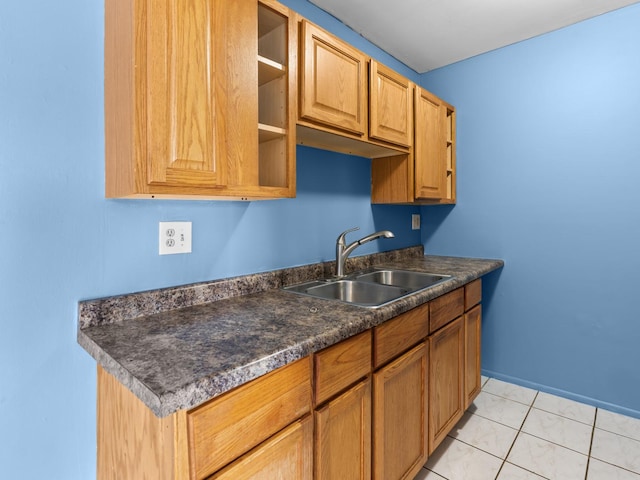 kitchen featuring a sink, dark countertops, open shelves, and baseboards