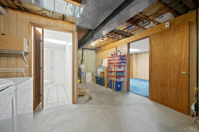 unfinished below grade area with washing machine and clothes dryer and wooden walls