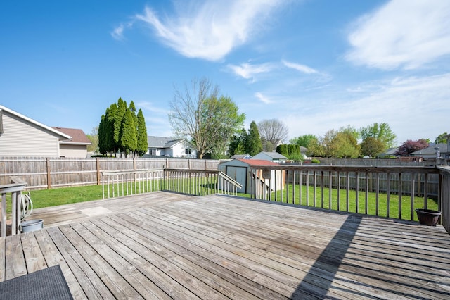 wooden terrace featuring a shed, an outbuilding, and a residential view