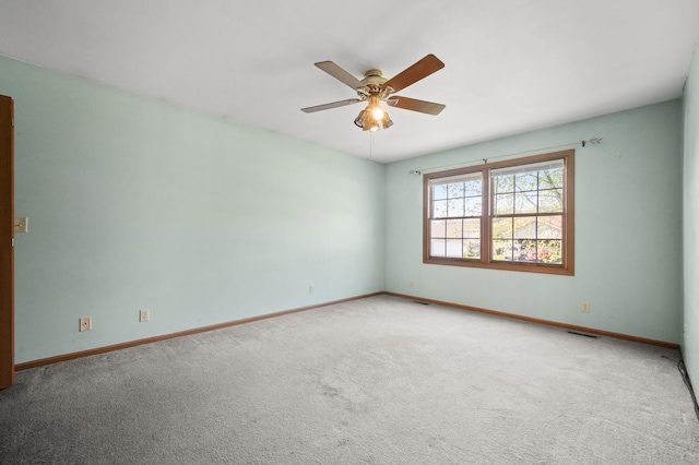 spare room with a ceiling fan, carpet floors, and baseboards