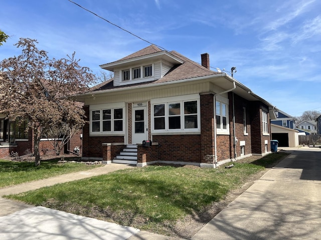 620 Lebanon St, Aurora, IL 60505 - bungalow-style home with brick siding, a chimney, an outbuilding, a front lawn, and roof with shingles