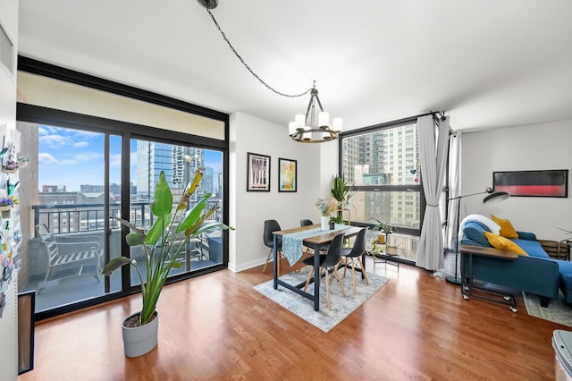 1160 S Michigan Ave Unit 1005, Chicago, IL 60605 - dining room featuring a city view, a chandelier, wood finished floors, and baseboards