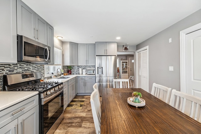 31 Bruce Ct N, Lockport, IL 60441 - kitchen with stainless steel appliances, gray cabinetry, a sink, backsplash, and light wood-style flooring
