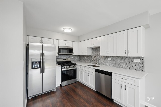 kitchen featuring appliances with stainless steel finishes, a sink, decorative backsplash, and light countertops