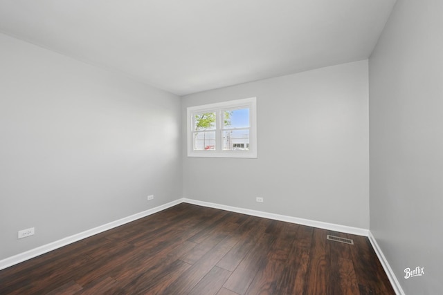 empty room with dark wood-style flooring and baseboards