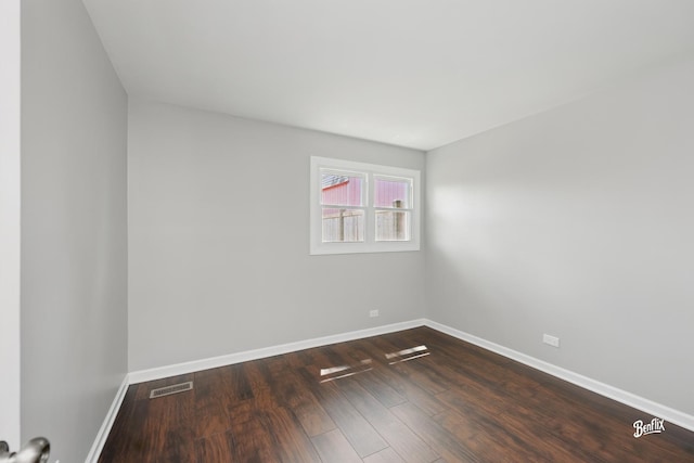 spare room featuring baseboards and dark wood-style floors