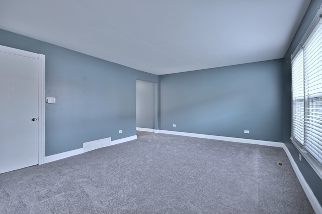 unfurnished room with carpet floors and baseboards