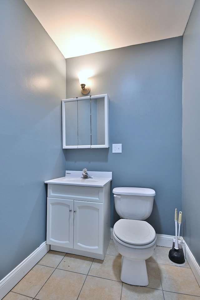 bathroom with baseboards, toilet, tile patterned flooring, and vanity