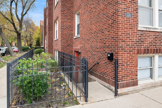 view of home's exterior featuring fence and brick siding