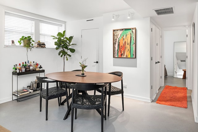 dining area featuring baseboards and concrete flooring