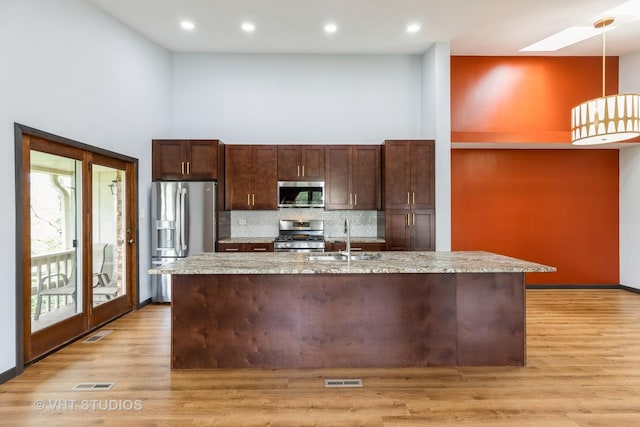 17581 Windsor Pkwy Unit 1, Tinley Park, IL 60477 - kitchen with appliances with stainless steel finishes, a sink, a skylight, decorative backsplash, and light wood-style flooring