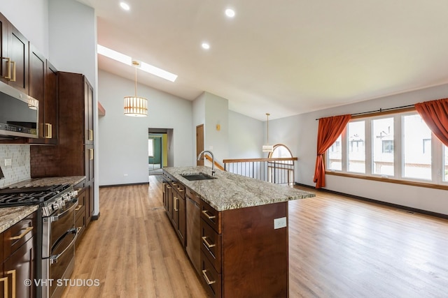 17581 Windsor Pkwy Unit 1, Tinley Park, IL 60477 - kitchen featuring appliances with stainless steel finishes, a sink, light wood finished floors, a center island with sink, and vaulted ceiling