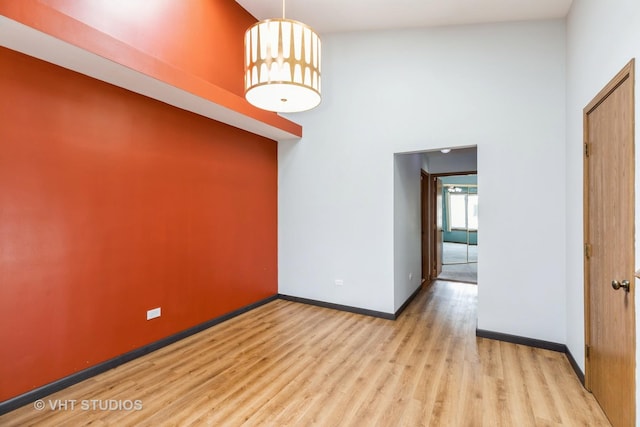 17581 Windsor Pkwy Unit 1, Tinley Park, IL 60477 - unfurnished room with wood finished floors, a high ceiling, and baseboards