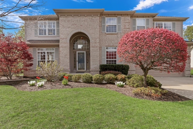 view of front of house featuring a front lawn, brick siding, a garage, and driveway