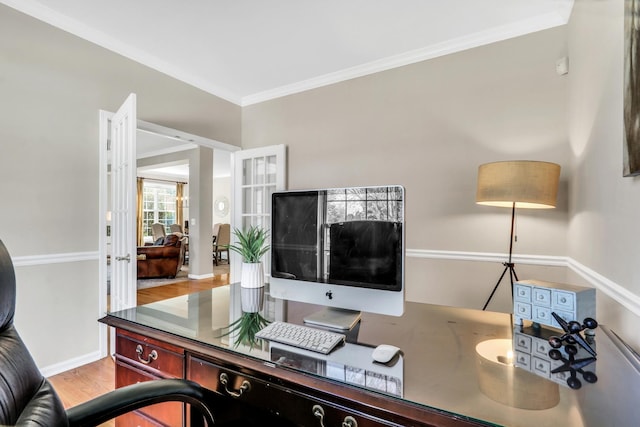 home office featuring crown molding, wood finished floors, and baseboards