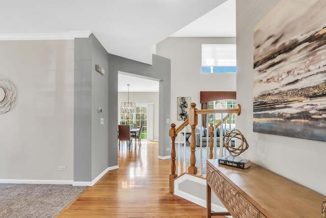 entryway with light wood-style flooring, a chandelier, and baseboards