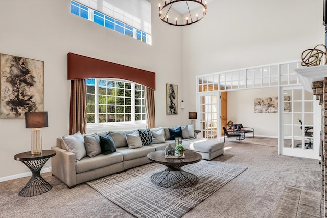 living area featuring french doors, carpet floors, a high ceiling, a chandelier, and baseboards