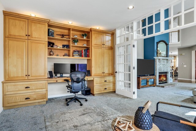 office area with built in study area, carpet floors, recessed lighting, a brick fireplace, and baseboards