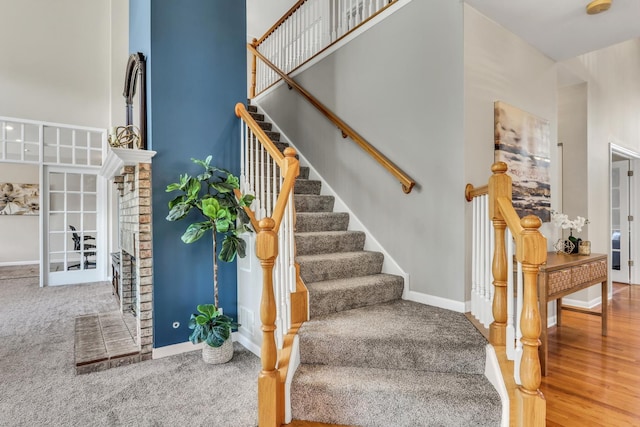 stairs with baseboards, a high ceiling, french doors, and carpet