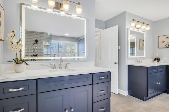 bathroom with a tile shower, two vanities, and tile patterned floors