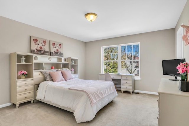 bedroom with light carpet and baseboards